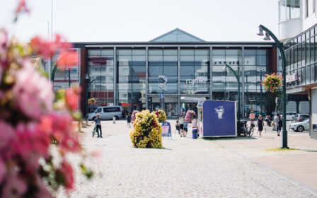 Ihmisiä kävelemässä ja syömässä jäätelöä kävelykadulla kesällä