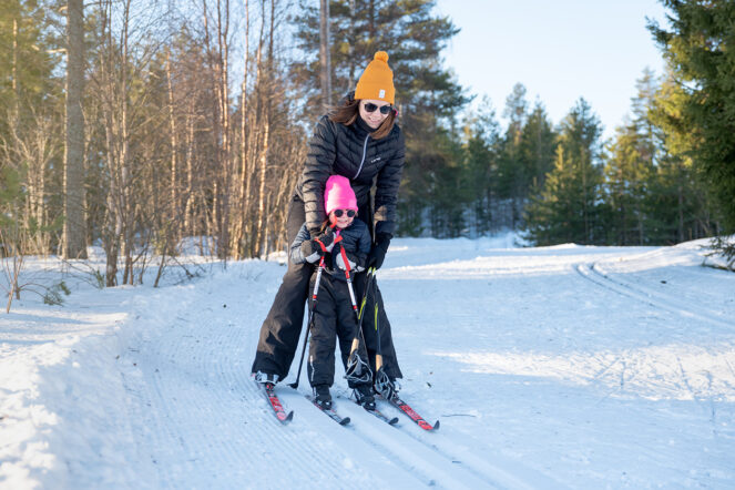Nainen ja lapsi hiihtävät