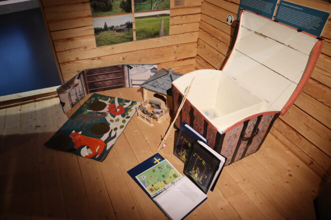 Kuvassa vanhanaikainen kapioarkku, jonka sisus on maalattu valkoiseksi ja ulkopuoli vaaleanpunaiselle pohjalle kukkakuvioita.