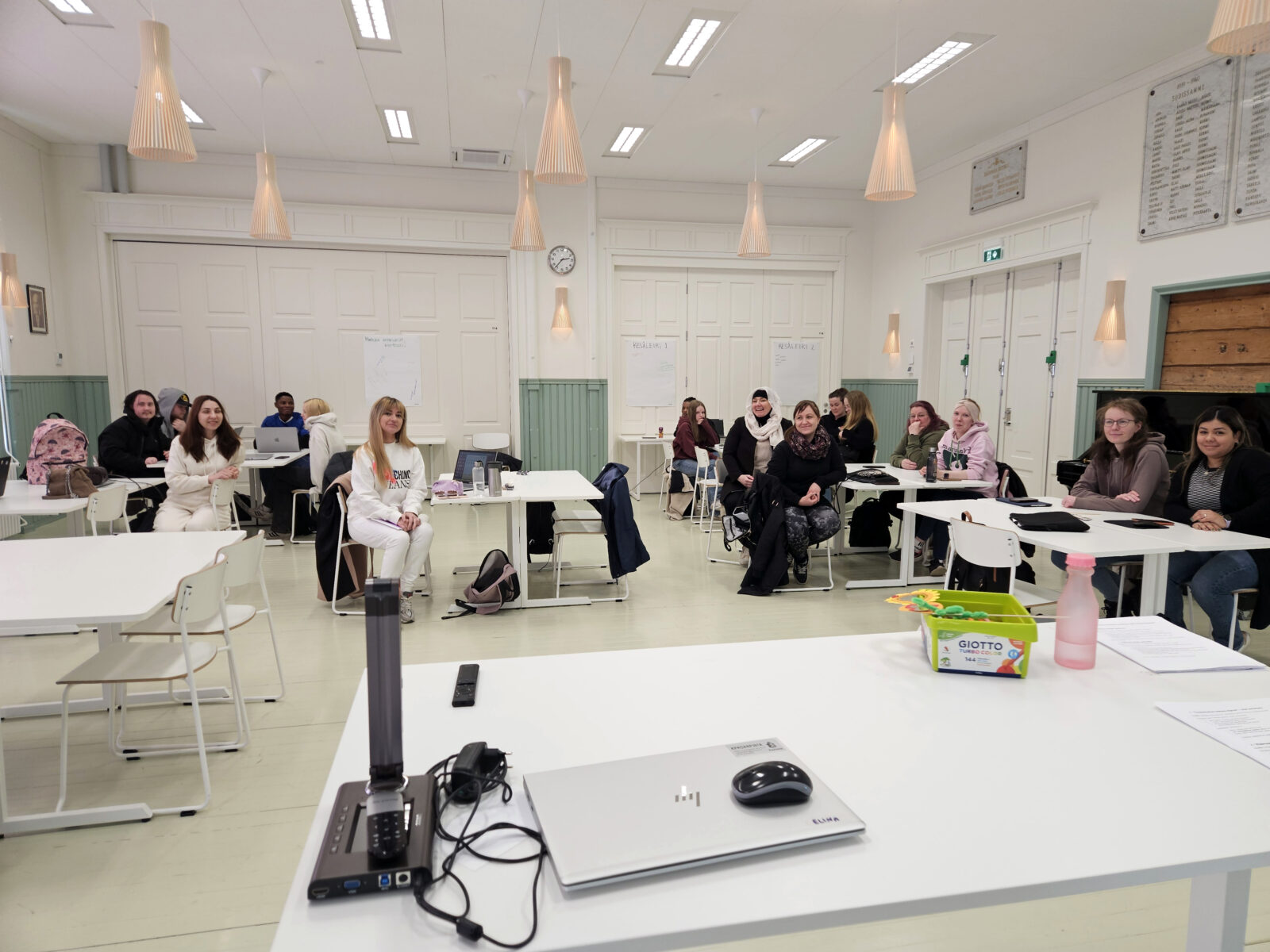 Nuoria ihmisiä istumassa luokkahuoneessa.