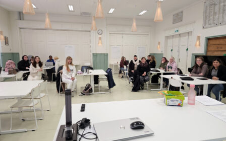 Nuoria ihmisiä istumassa luokkahuoneessa.